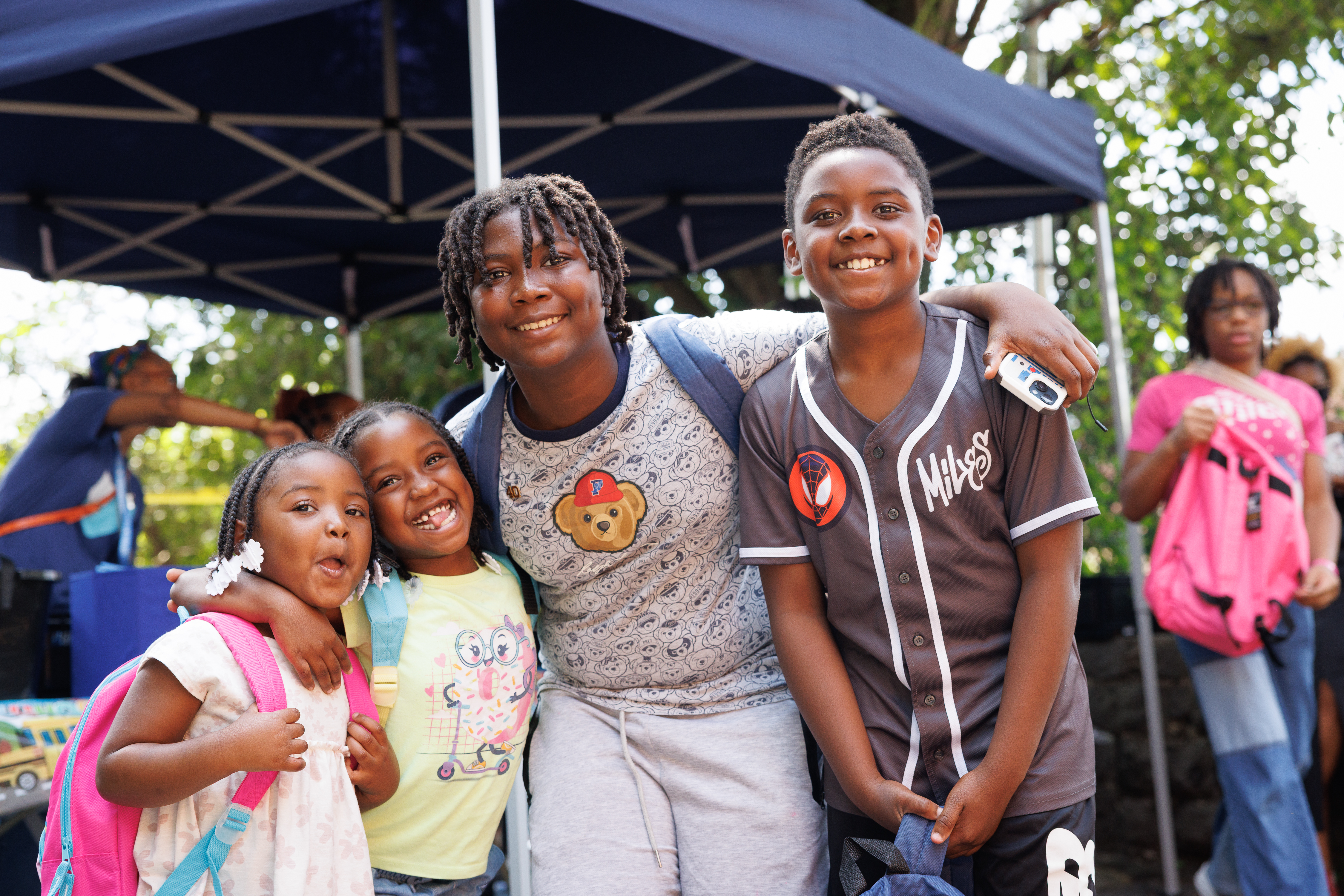 Children smiling, holding each other 