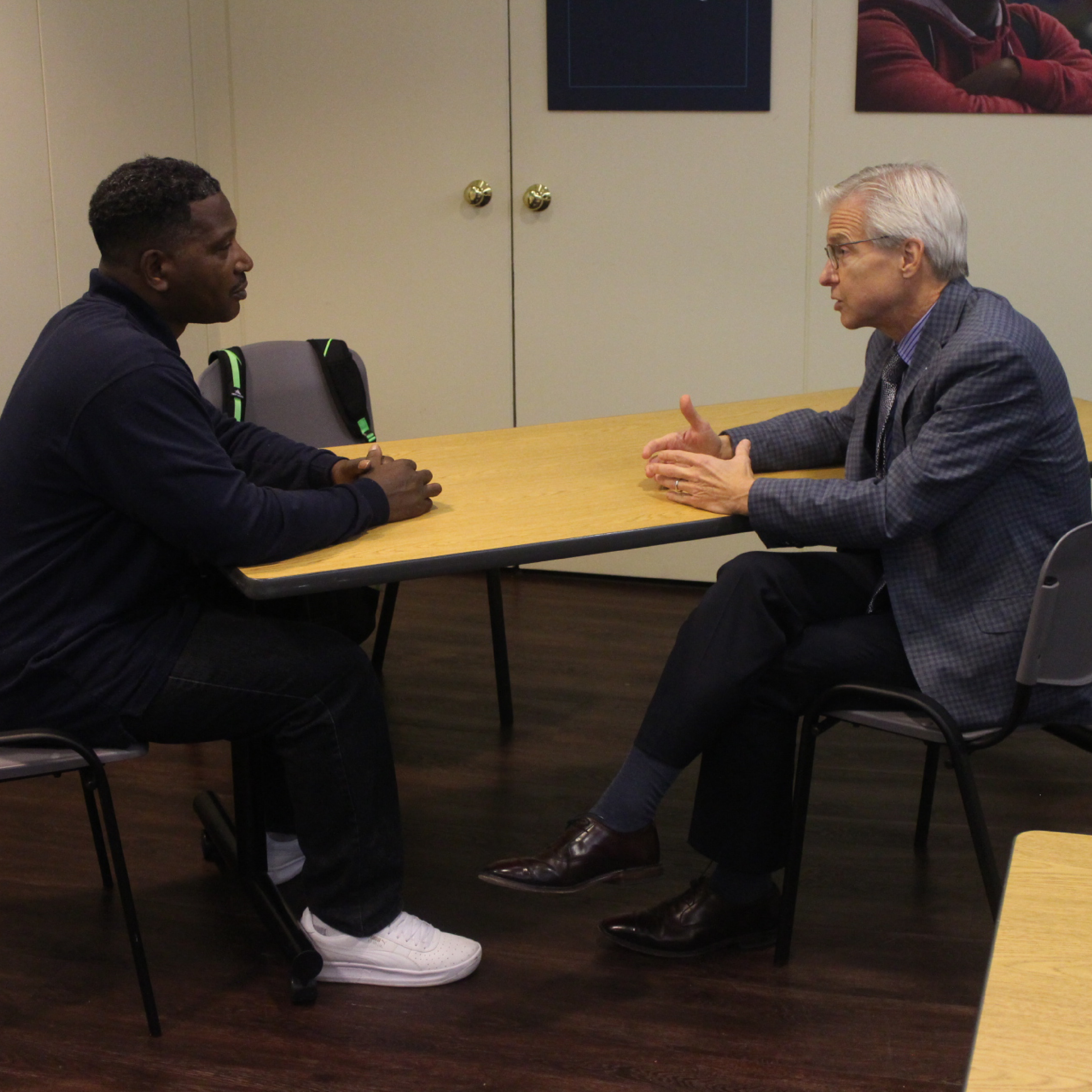 An ECS volunteer and board member helps a workforce development participant hone his interview skills